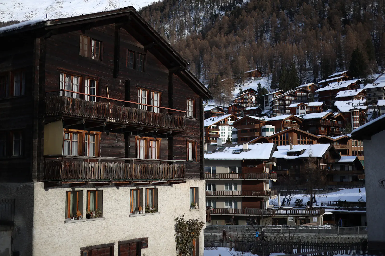 Verschneite Chalets in Schönried mit traditionellen Holzfassaden und Balkonen